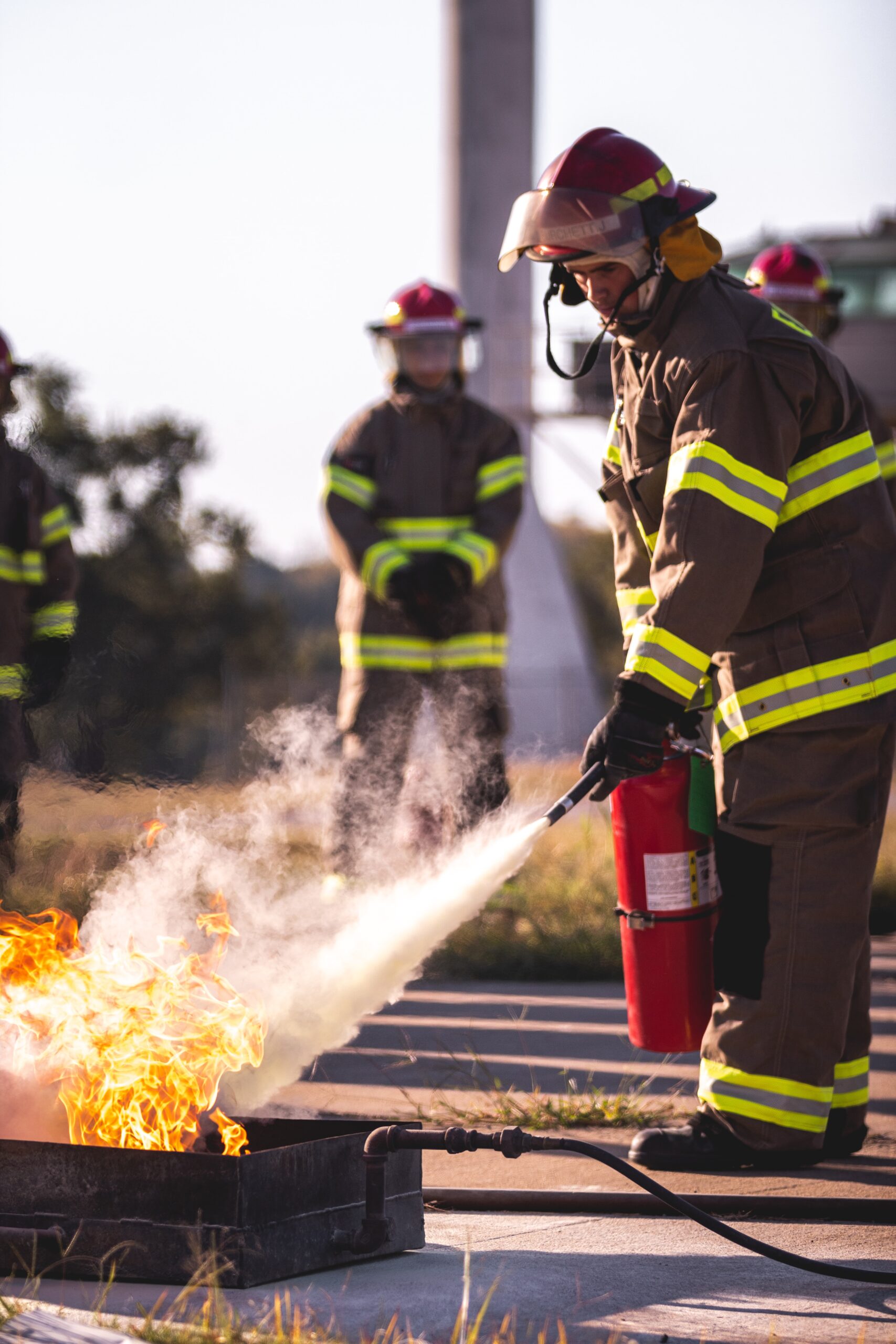 Bomberos dando una demostración práctica de formación contra incendios a otra gente.